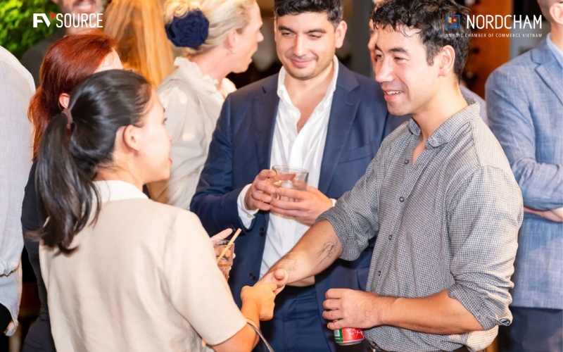 Ashley Le, Co-Founder and COO of FVSource, shaking hands with business partners at a NordCham Vietnam event.